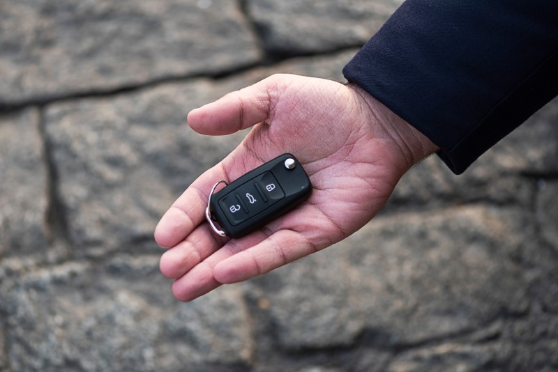 Mężczyzna trzyma w dłoni znaleziony na ulicy kluczyk samochodowy – ryzyko kradzieży auta po zgubieniu klucza